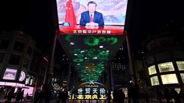 A large screen shows Chinese President Xi Jinping delivering a speech ahead of the New Year's eve celebrations in Beijing on December 31, 2024. (Photo by ADEK BERRY / AFP)