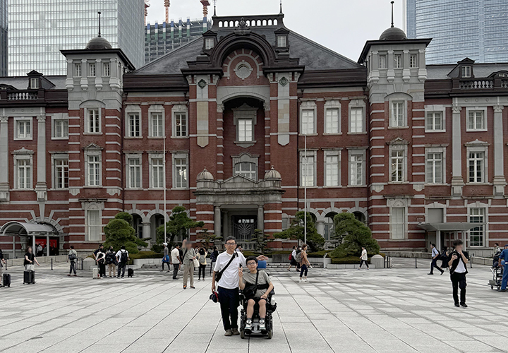 東京駅前で記念撮影をする、普段車いすで生活している中学生の坂本篤宣くん