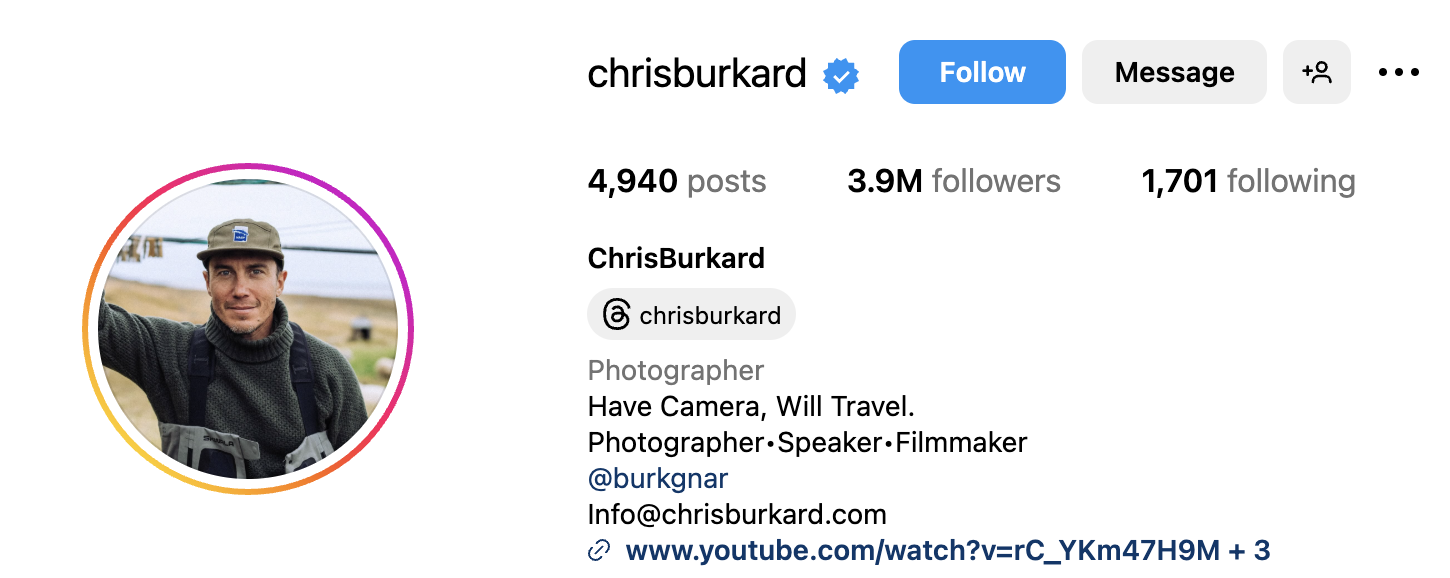 Renowned adventure photographer Chris Burkard capturing the Northern Lights while standing on snow-covered terrain in Iceland, showcasing his signature style of blending extreme landscapes with human elements.