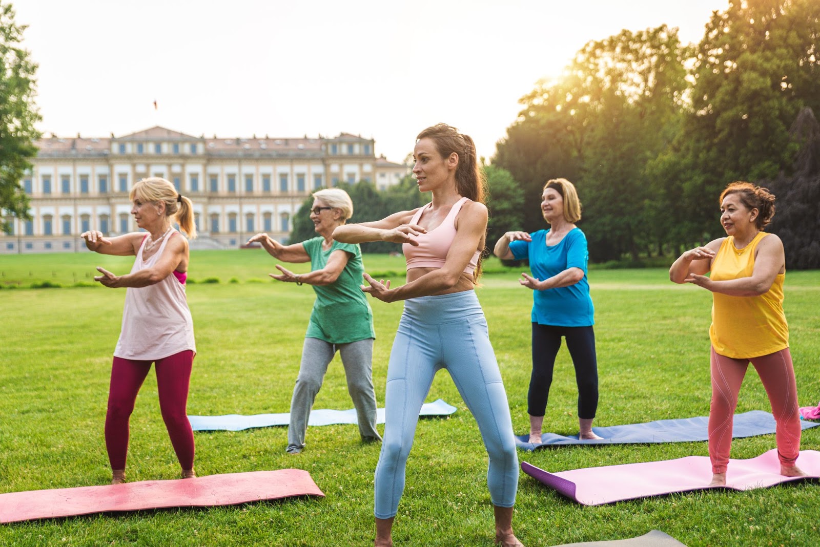 Mulheres seniores treinando com preparador físico no parque