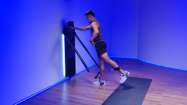 A man performing a leg raise exercise on an all-in-one workout machine, demonstrating its versatility for full-body workouts in minimal space