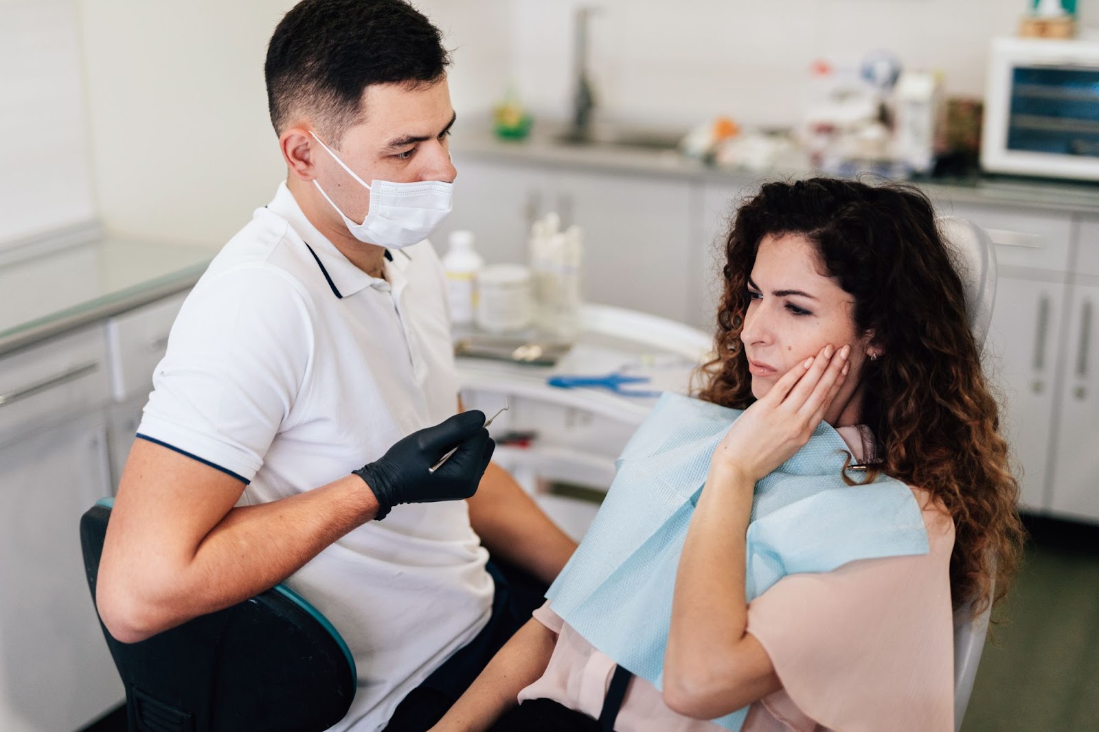 Dentist consulting a female patient with a toothache in a clinic.








