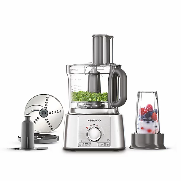 A Kenwood food processor and blender with various attachments next to it, including a chopping blade, slicing disc, and smoothie cup.