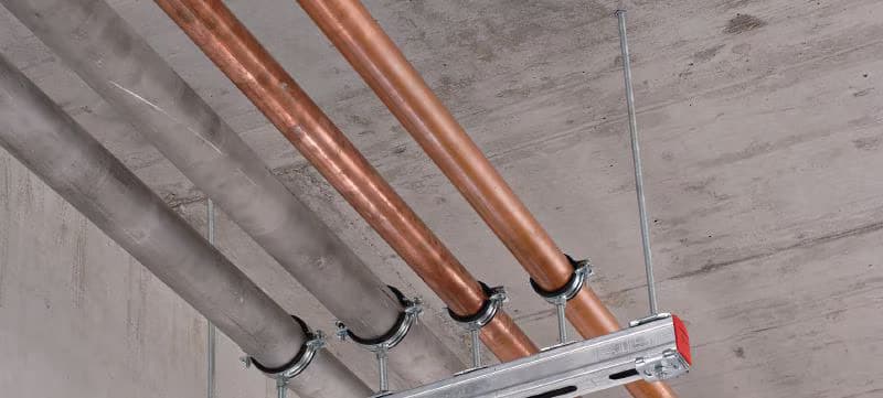 Tắc kê đạn inox neo máy móc và máng dây điện trong nhà xưởng công nghiệp.