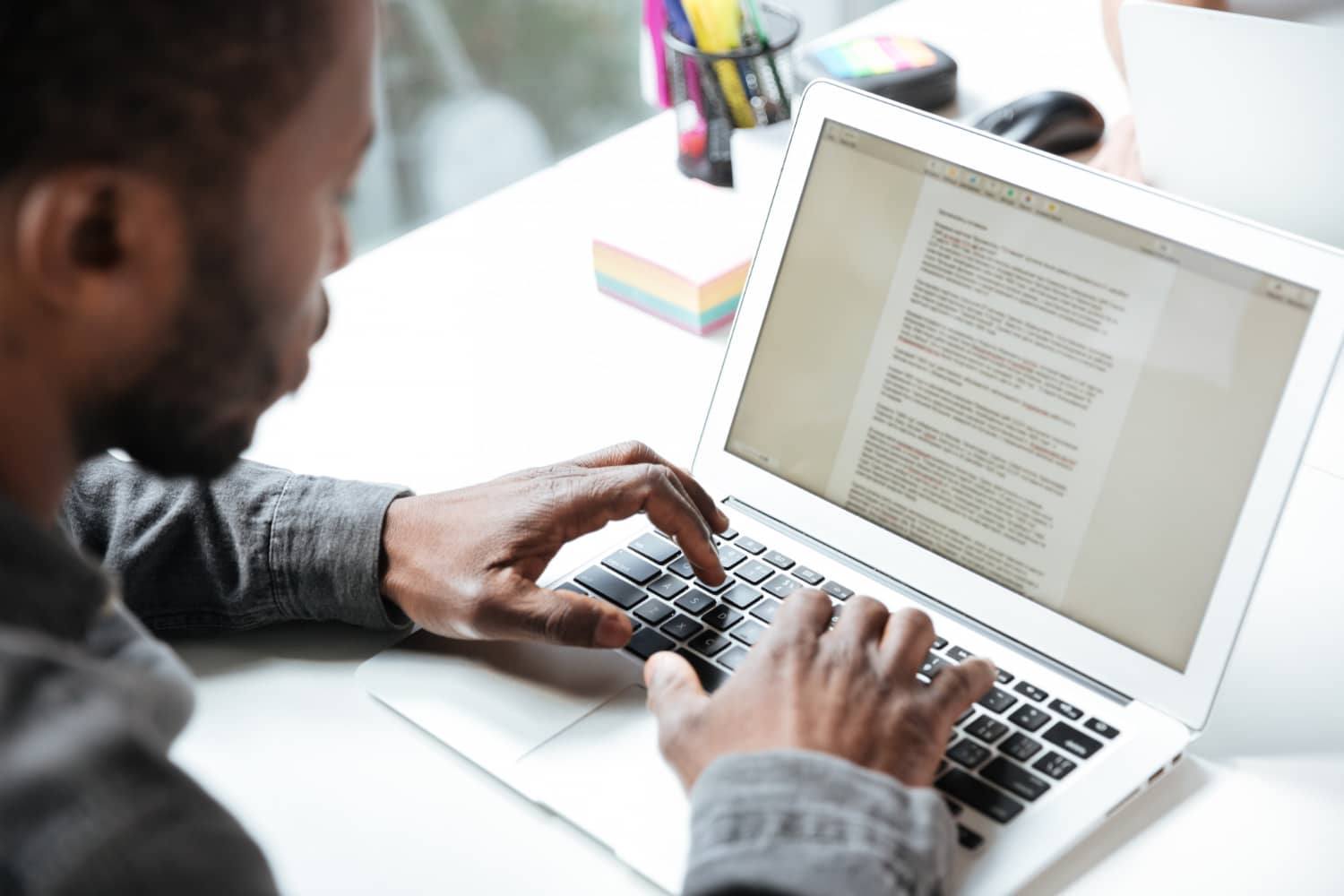 a black man typing on a laptop 