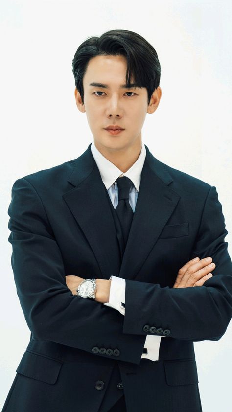 This contains an image of yoo Yeon seok in a suit and tie with his arms crossed