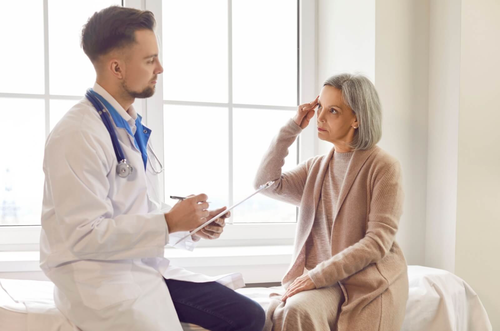 An older adult sharing symptoms with a healthcare professional during a cognitive assessment.