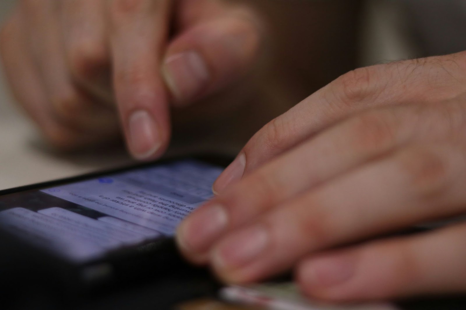 Close-up of hands typing a message on a smartphone