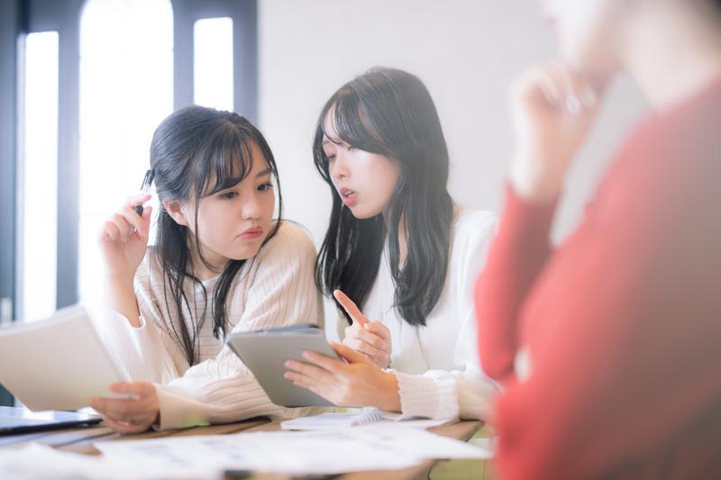 メモ帳を手にして相談する2人の女性