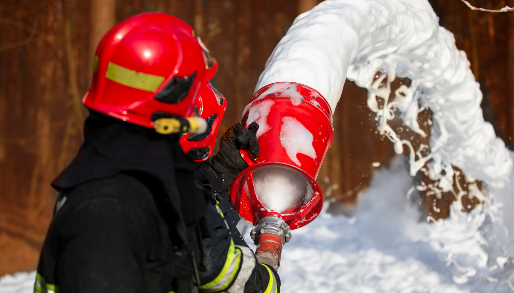 A firefighter spraying water from a fire hose

Description automatically generated