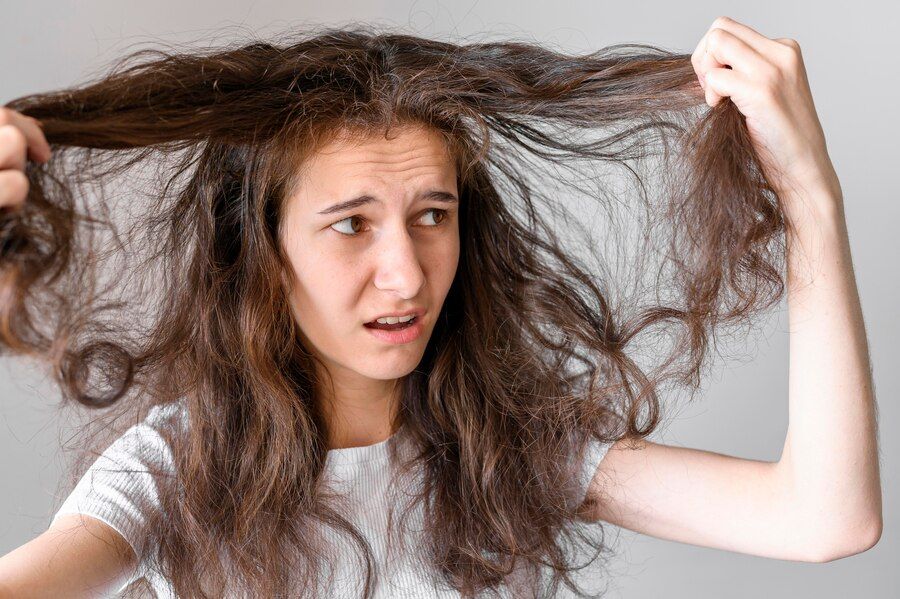 Agitated Woman holding her tangled flyaway hair