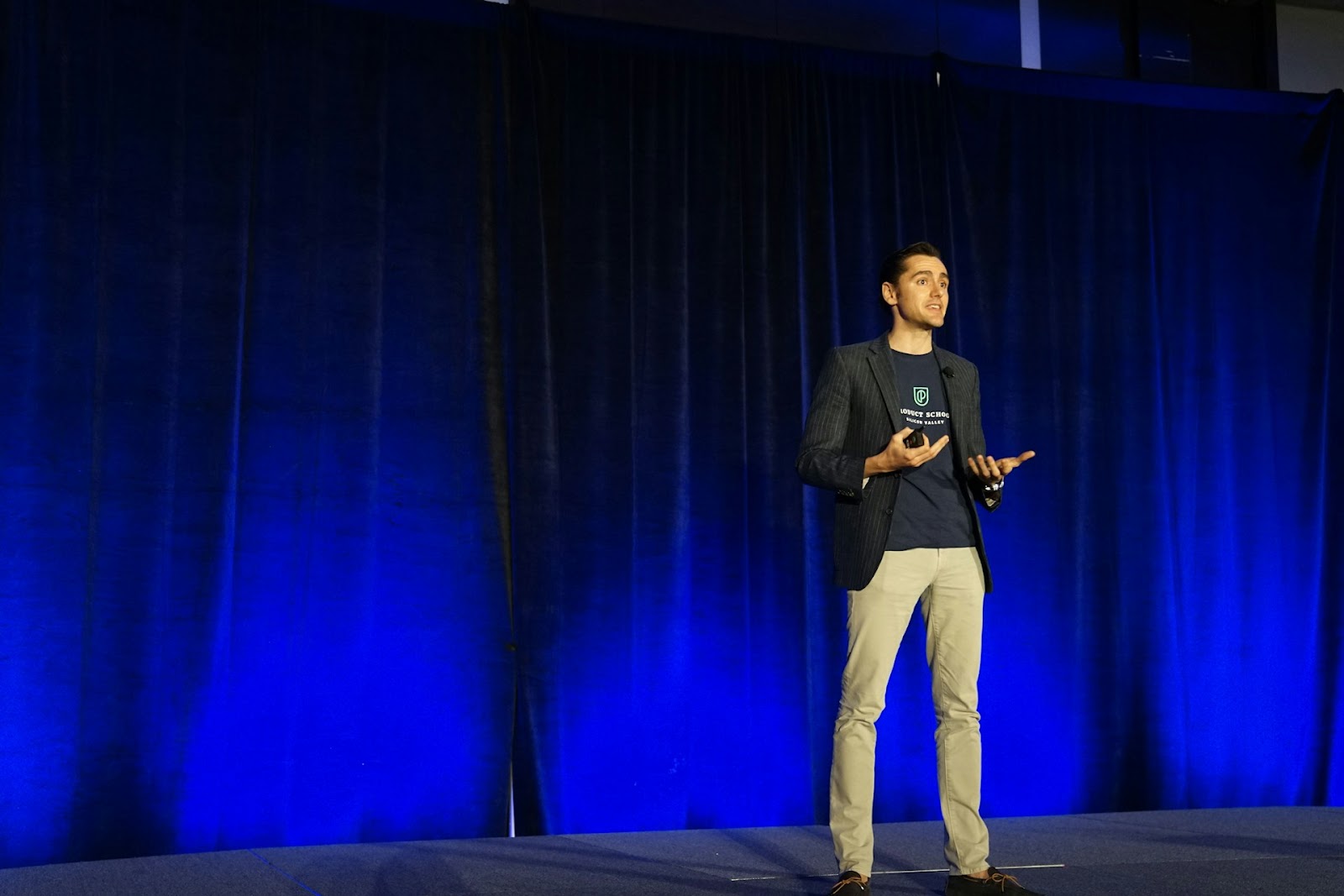 A man on stage making a persuasive speech.