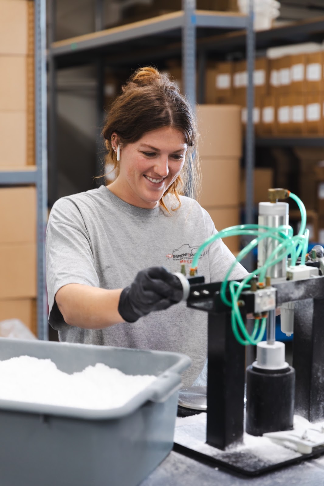 Production manager Cam smiling and pressing the buttons on the hydraulic press