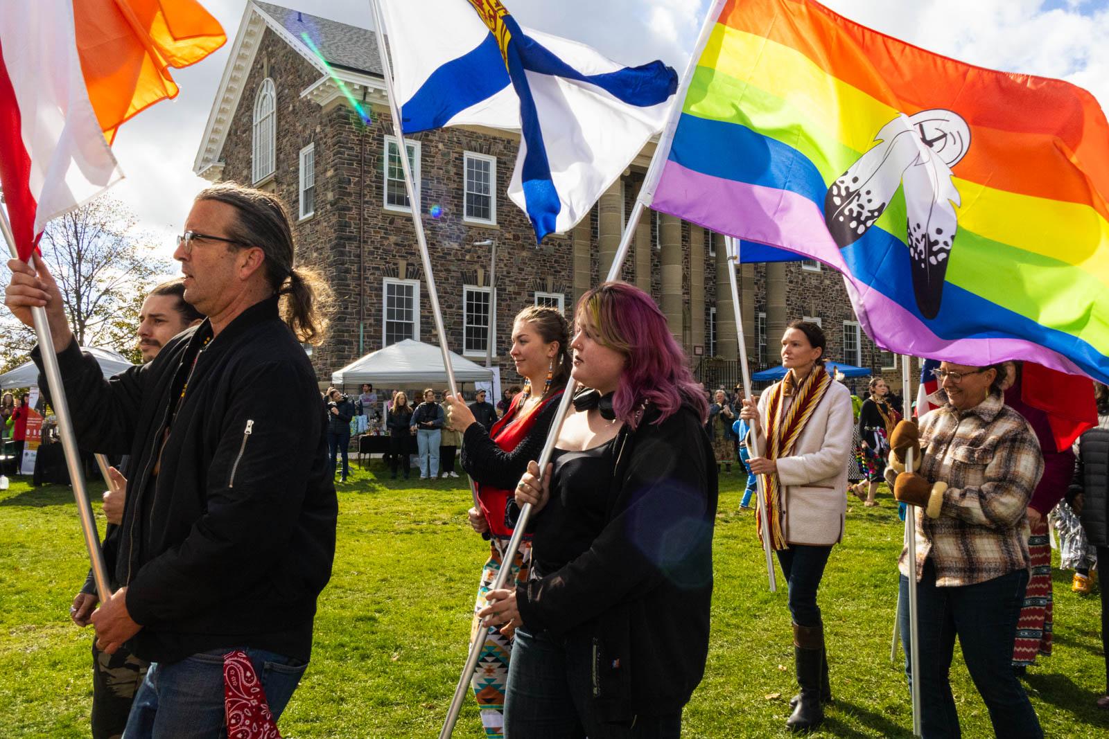 A group of people holding flags

Description automatically generated