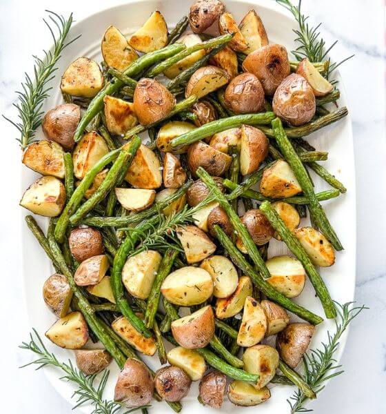 Roasted potatoes and green beans on white serving plate