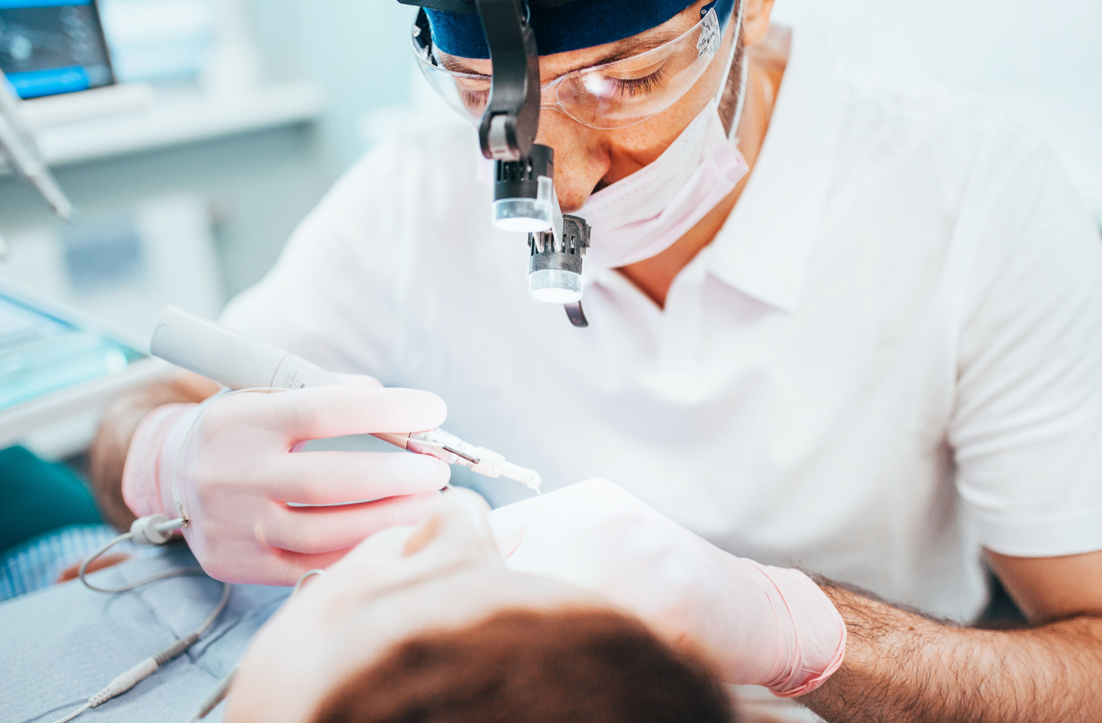 A dentist starts by examining a patient's mouth in preparation for a root canal.