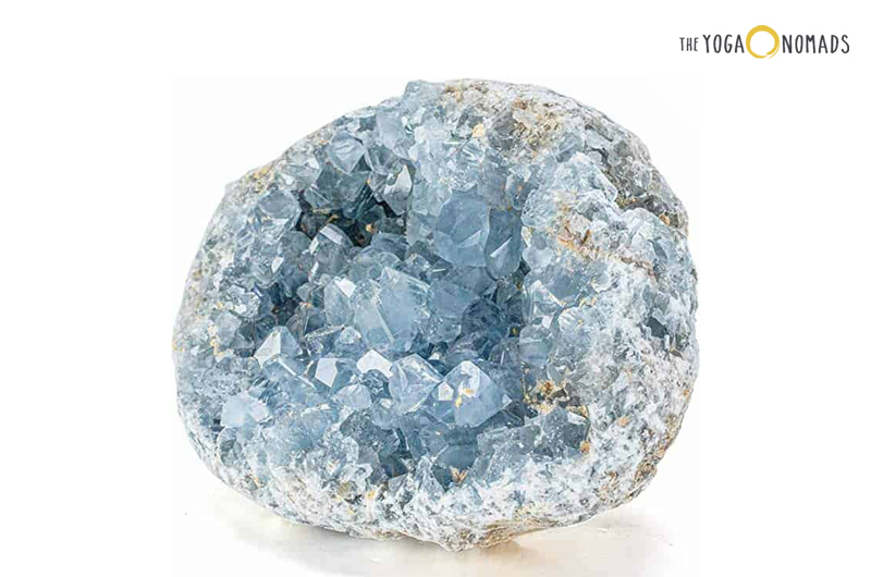 A mineral specimen known as celestite, characterized by pale blue crystal formations embedded within a greyish-white rock matrix. The crystals are translucent to transparent and reflect light, giving them a slightly shiny appearance.