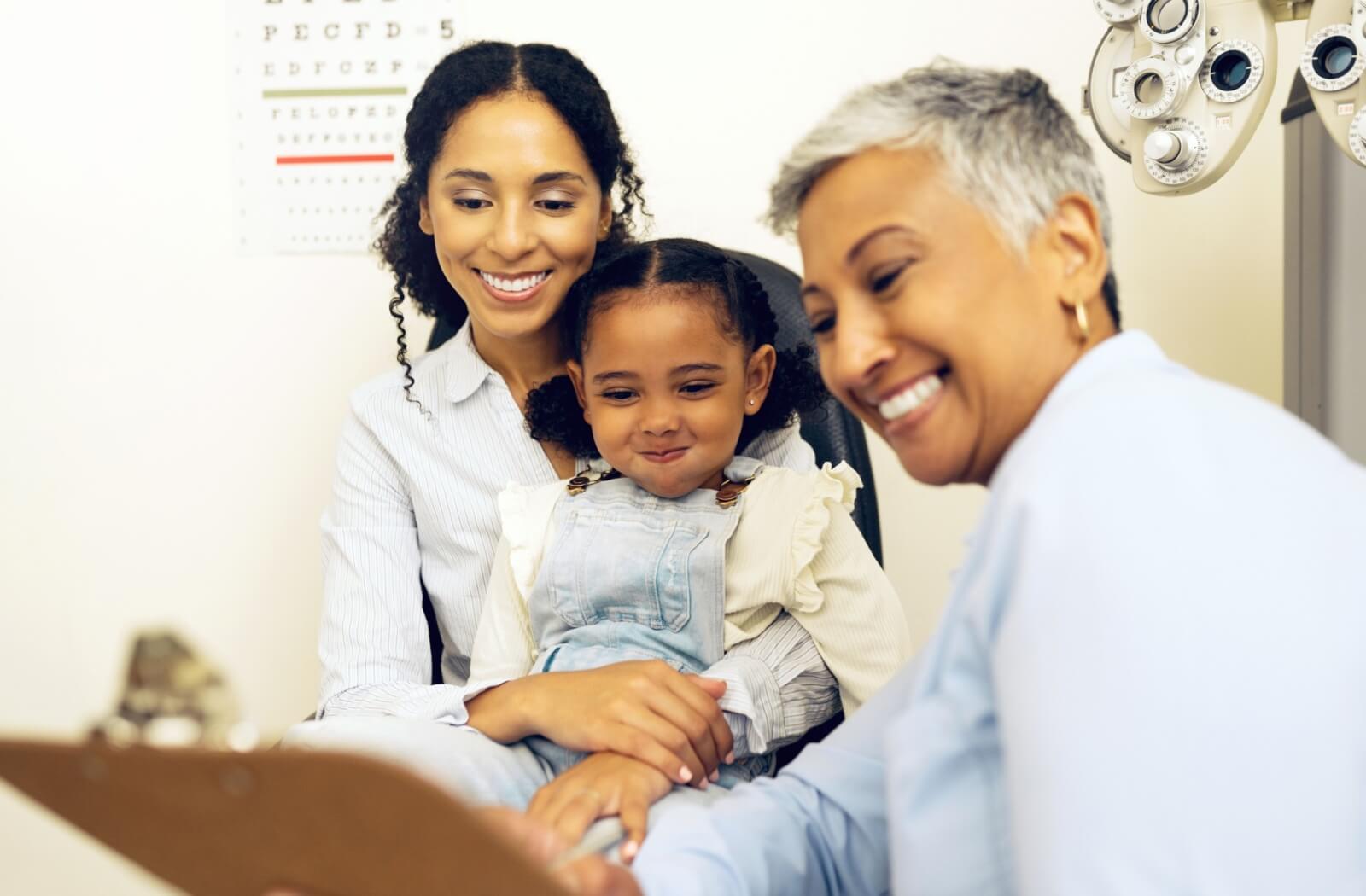 An optometrist shows a family the results of their comprehensive eye exams after testing for a genetic connection to glaucoma