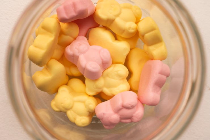 Assortment of delicious gummy bears with glass jar