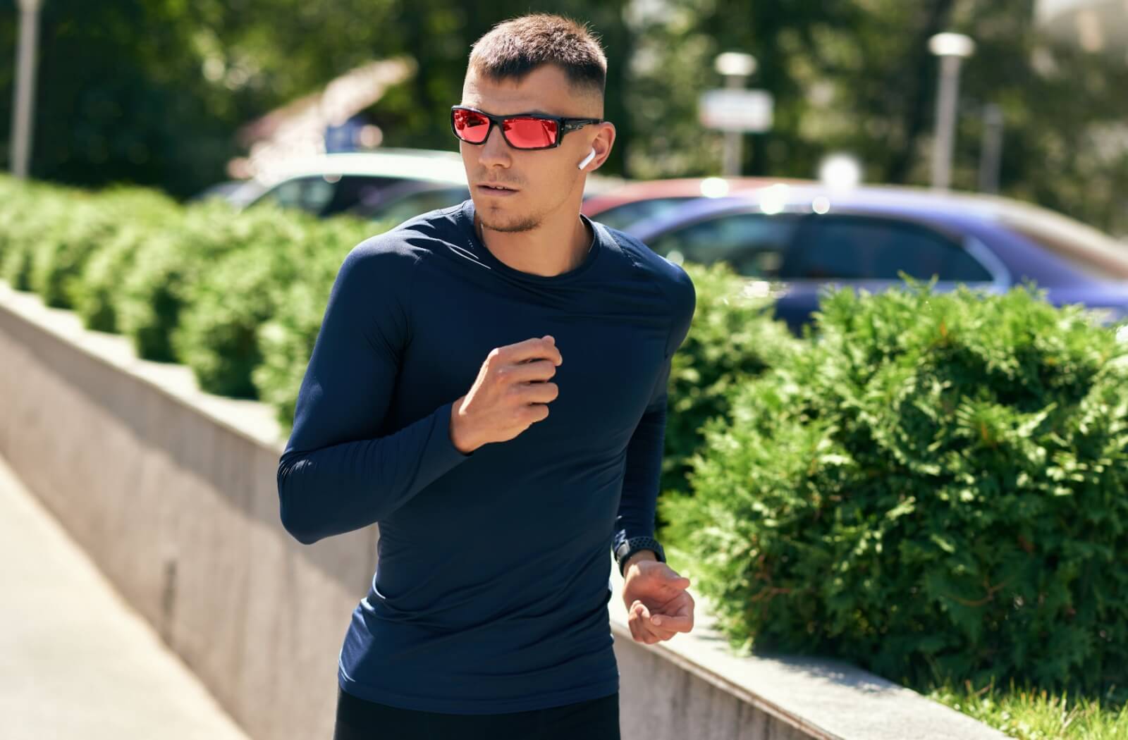 An athletic person jogging while wearing stylish and functional sunglasses.