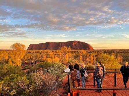 A group of people standing on a wooden platform overlooking a large rock formation

AI-generated content may be incorrect.