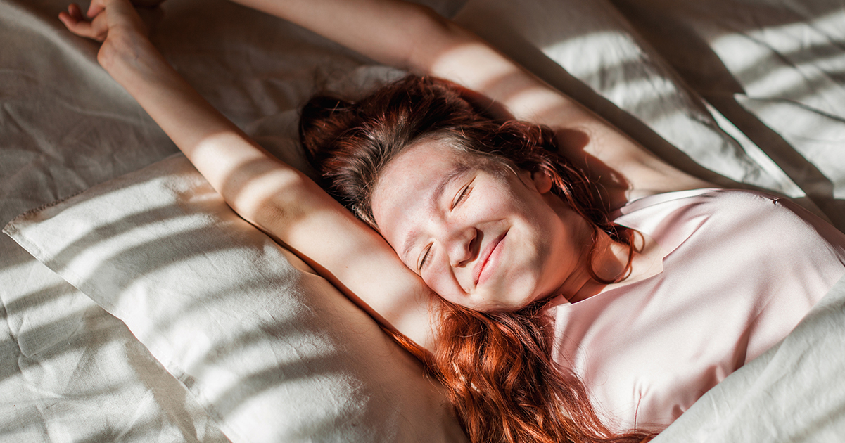 Woman stretches out in bed. Credit / Shutterstock