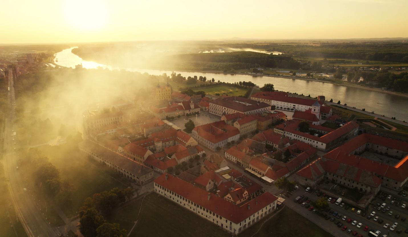 Aerial view of a town with red roofs

AI-generated content may be incorrect.