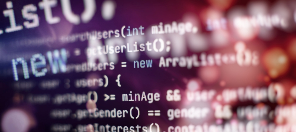 Close-up of JavaScript code displayed on a computer screen with a colorful, blurred background.