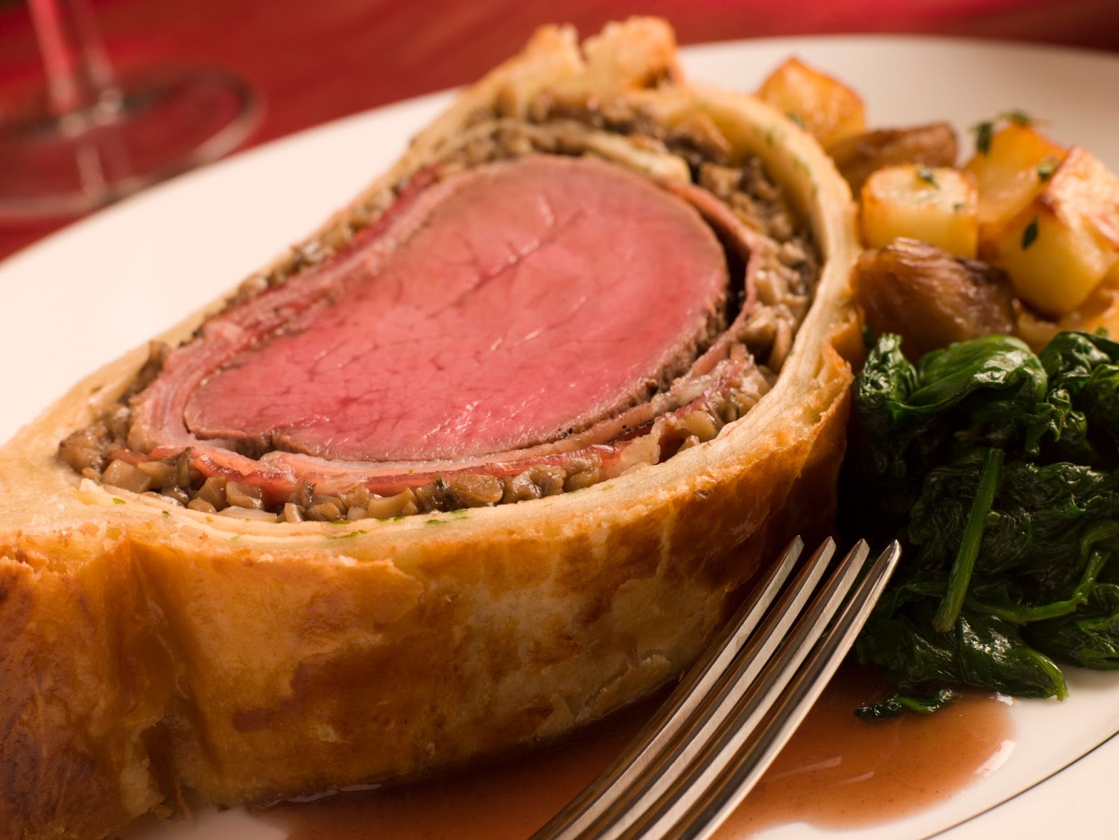 Beef Wellington served with potatoes and sauteed spinach