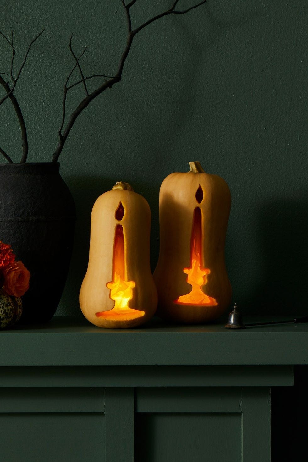 diy halloween decorations, two tall squashes on the mantel carved with candlestick designs