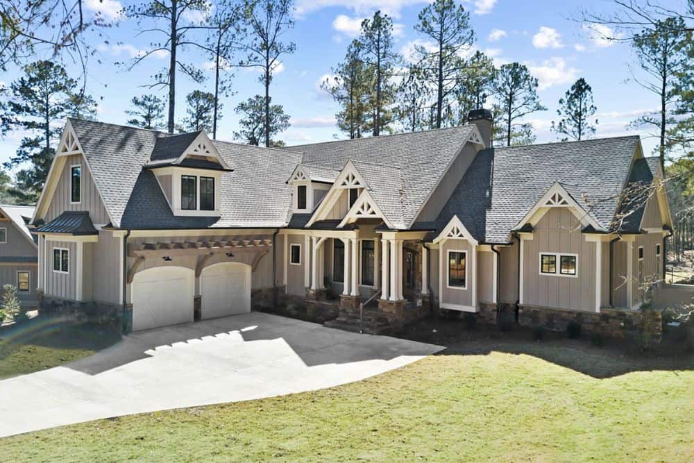 Angled front view showing the covered front porch and the side-entry garage topped with a gable dormer.
