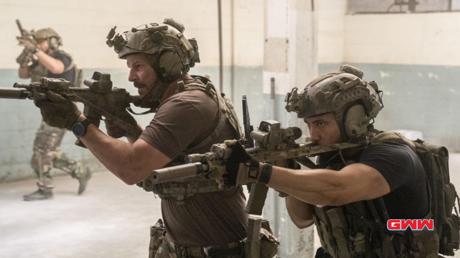 Jason and Raymond aiming rifles during indoor tactical training session.