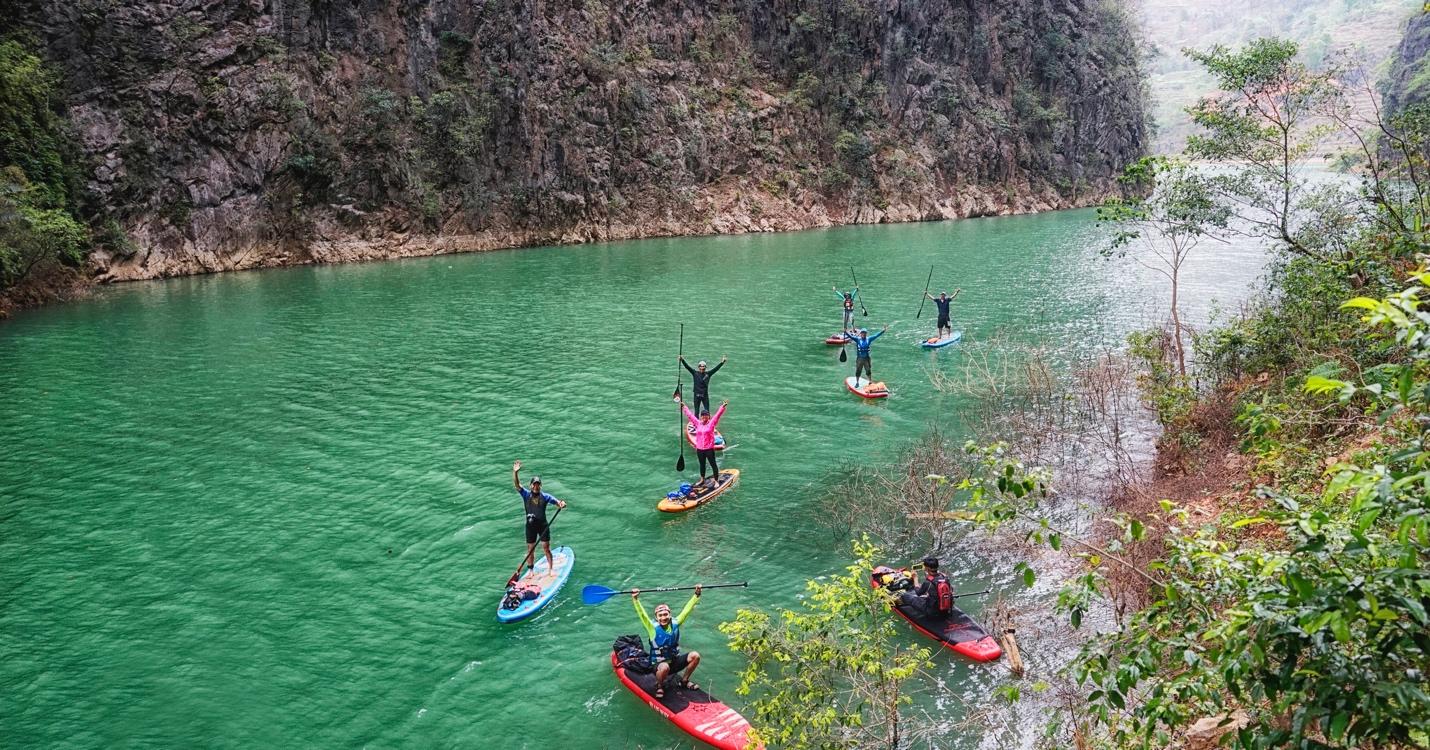 A group of people on paddle boards in a river

Description automatically generated