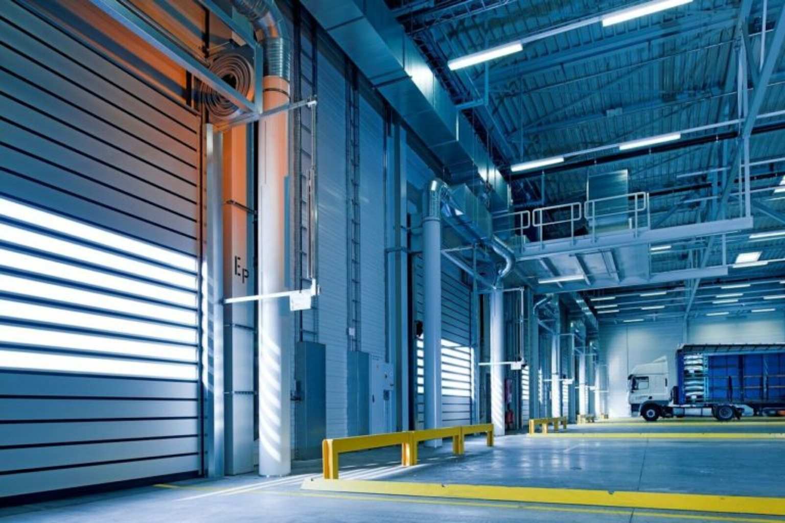 A modern warehouse with security barriers and a truck inside, highlighting warehouse security technology