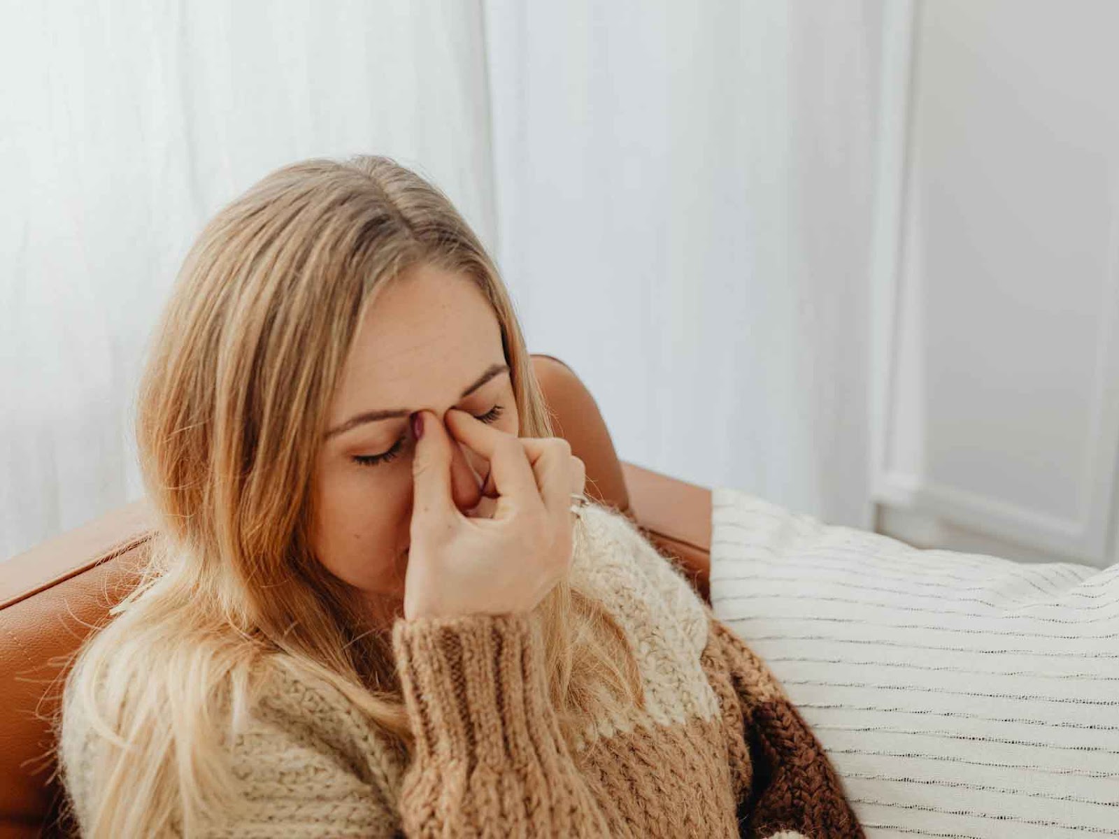 A woman is rubbing her forehead, displaying symptoms of anxiety that are impairing her vision.