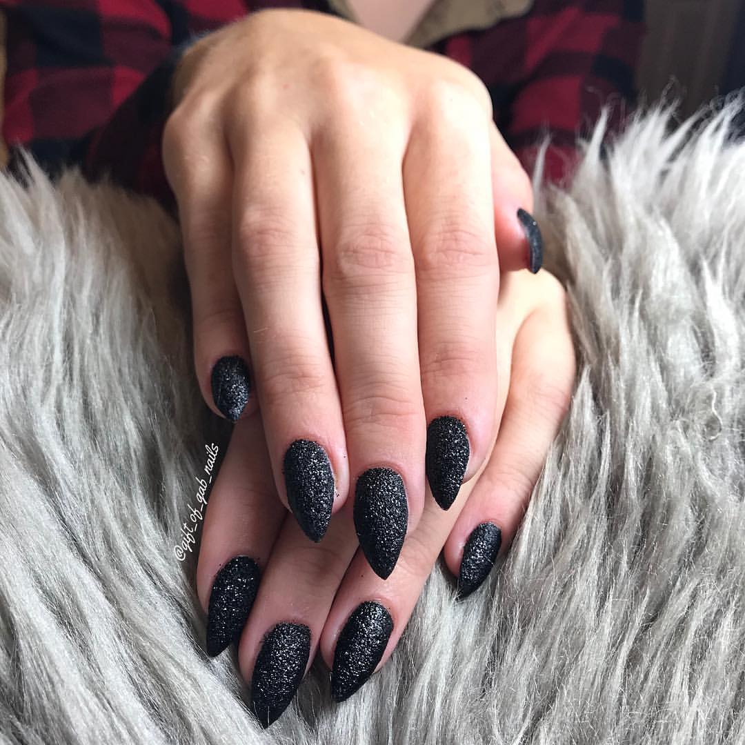 Close-up of a person's hands with black nails having Black Sugar Effect