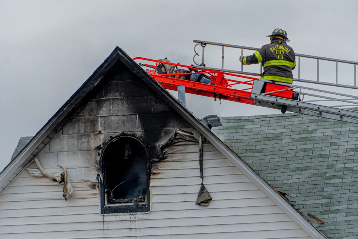 firemen on a fire damaged roof