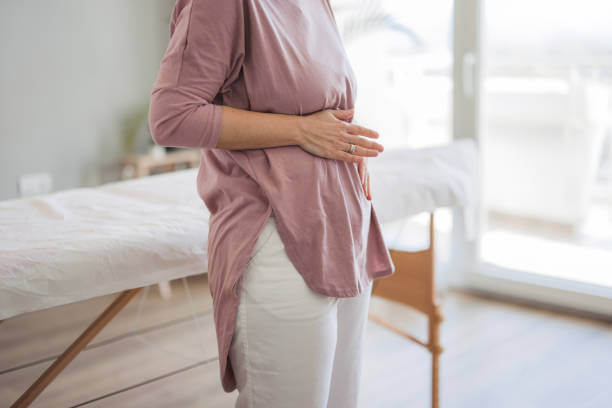 A woman holding her stomach, depicting discomfort from bloating.