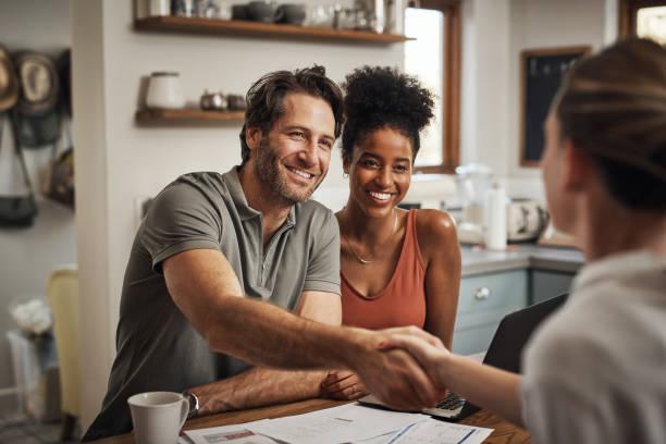 We're sure that you'll get us the best deal Cropped shot of a handsome middle aged man shaking hands with a financial advisor during a consultation at home Trusted life insurance stock pictures, royalty-free photos & images
