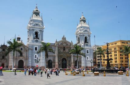 A large building with towers and people walking in front with Cathedral of Lima in the background

Description automatically generated