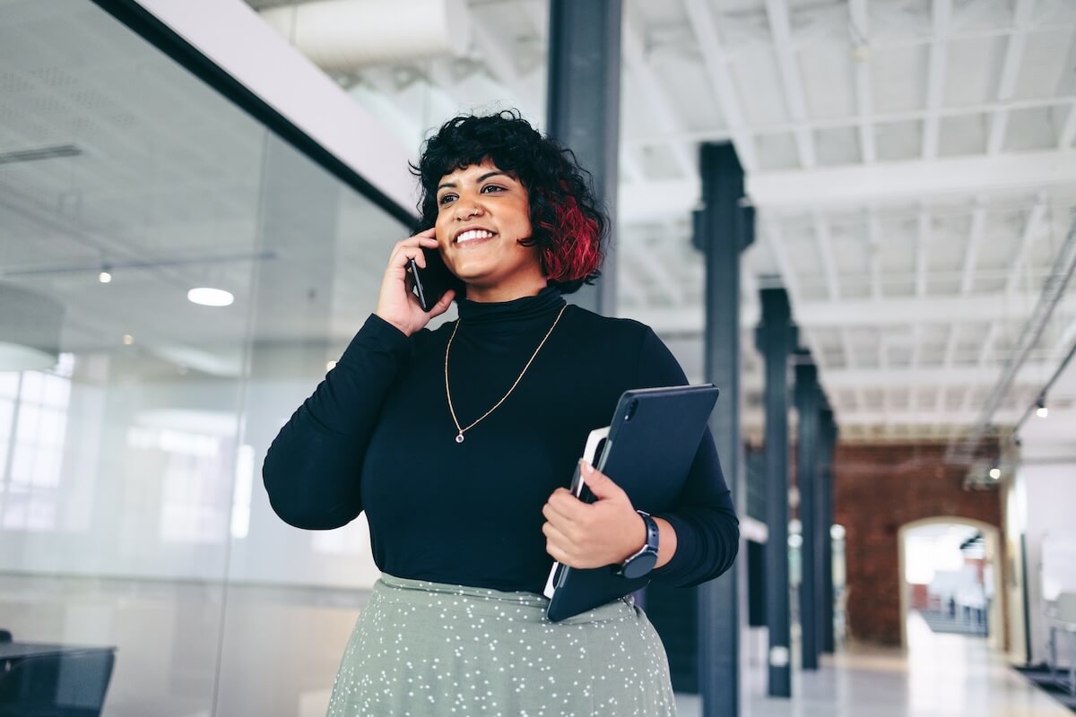 Employee talking on the phone while carrying her things