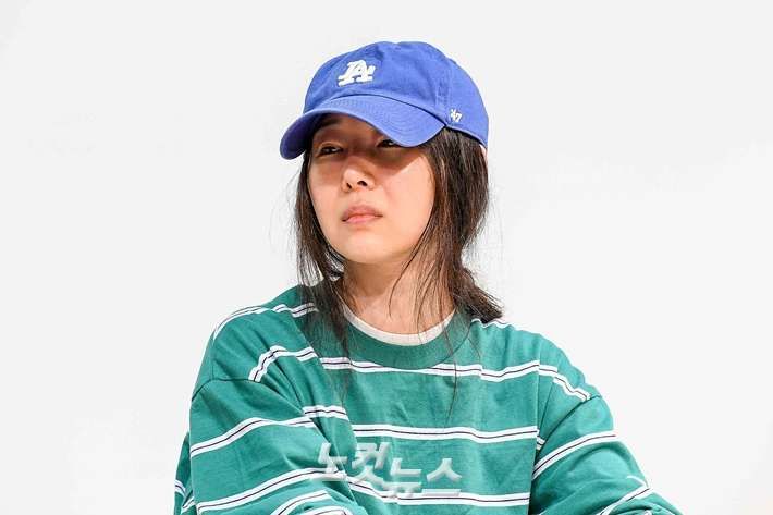 This contain Min Hee-jin has wearing a blue hat and green shirt