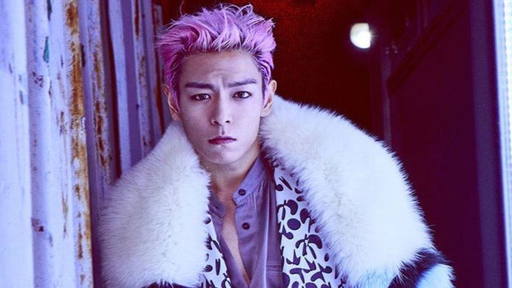  This contains an image of TOP with a pink hair wearing a leopard print jacket and white fur collar standing in an open doorway