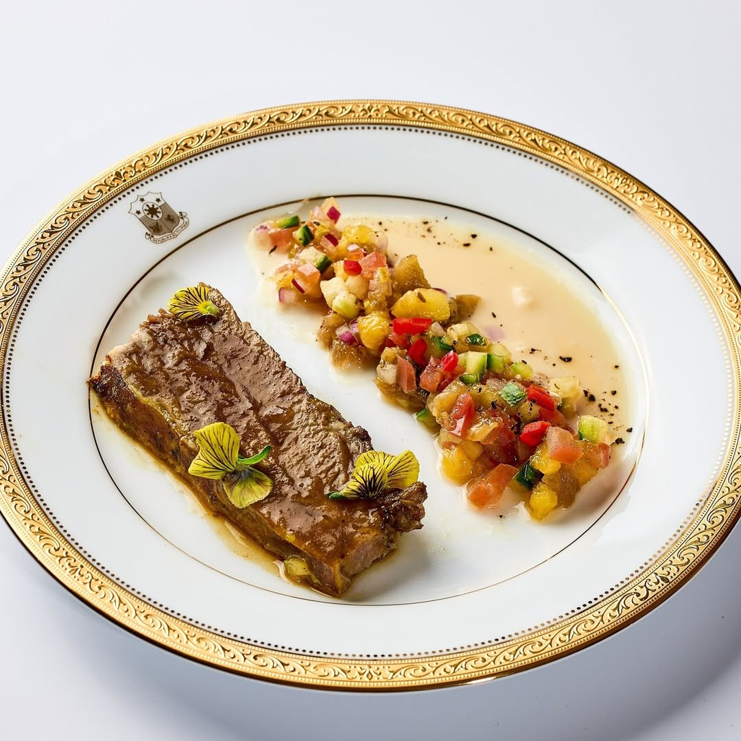 A plate of food with a gold rimDescription automatically generated