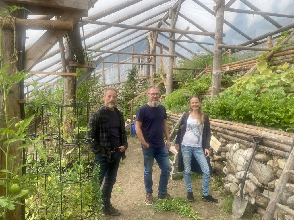 A group of people standing in a greenhouse  Description automatically generated