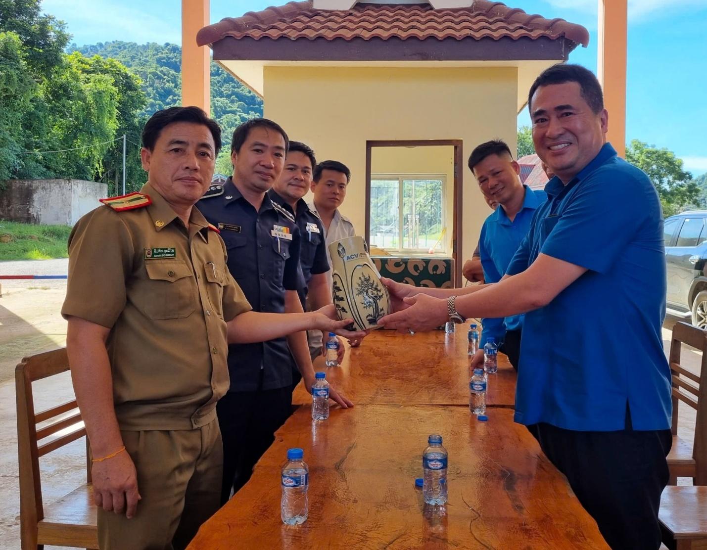 A group of men standing around a table with water bottlesDescription automatically generated