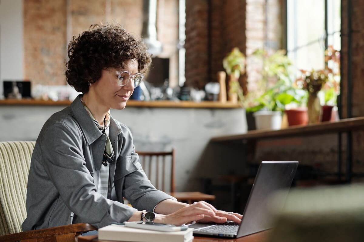 Claims intake process: curly-haired employee using a laptop