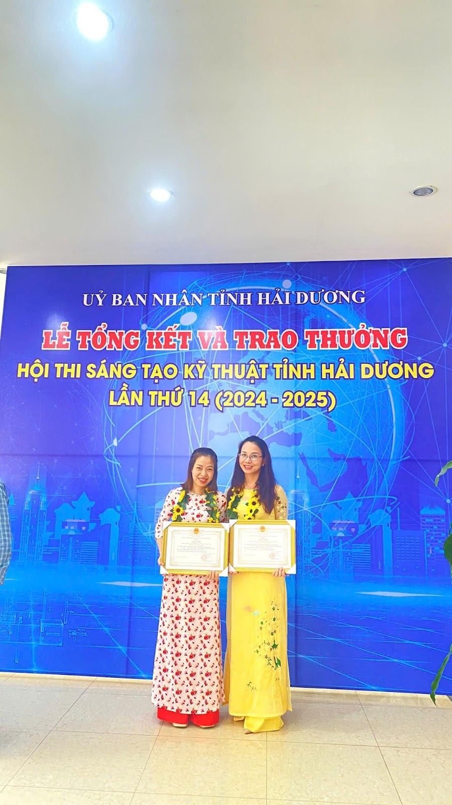Two women standing in front of a banner
AI-generated content may be incorrect.
