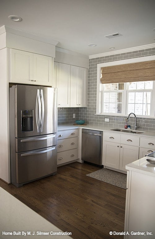 White framed windows above the sink bring in ample natural light.