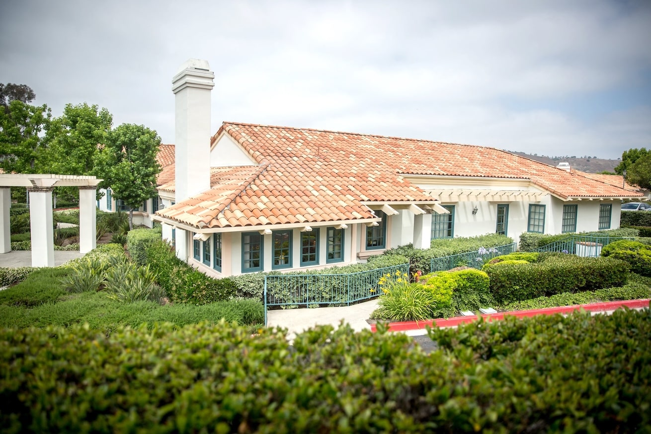 View of a California residential mental health treatment center with a terracotta roof and landscaped gardens.